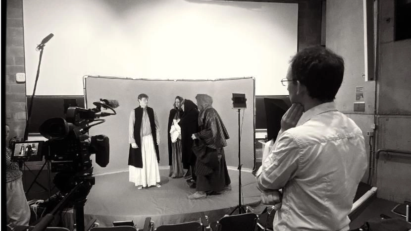 A group of Trinity students wearing historical dress on a film set.