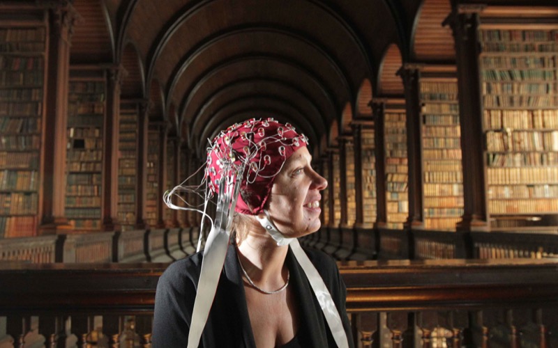 Associate professor in psychology, Robert Whelan, demonstrates his electroencephalogram (EEG) machine on senator and professor of law at Trinity, Ivana Bacik, in Trinity’s Long Room.
