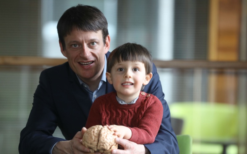 Professor Rhodri Cusack inspects a brain with a helping hand from his son, Calin Cusack.