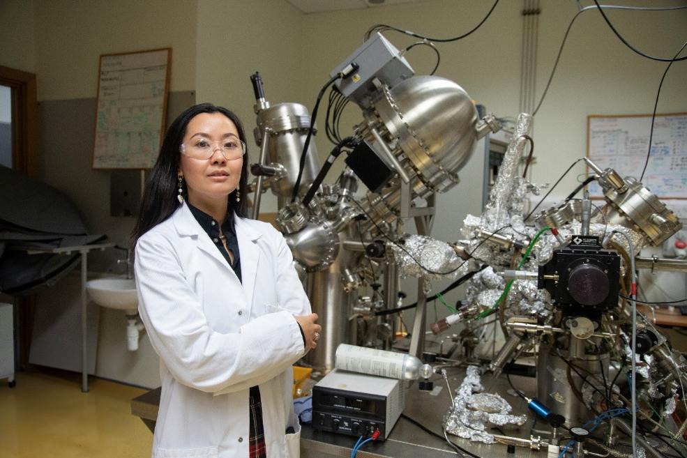 A scientist standing beside steel laboratory equipment