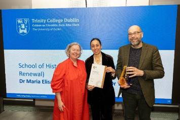 3 people standing together holding a certificate