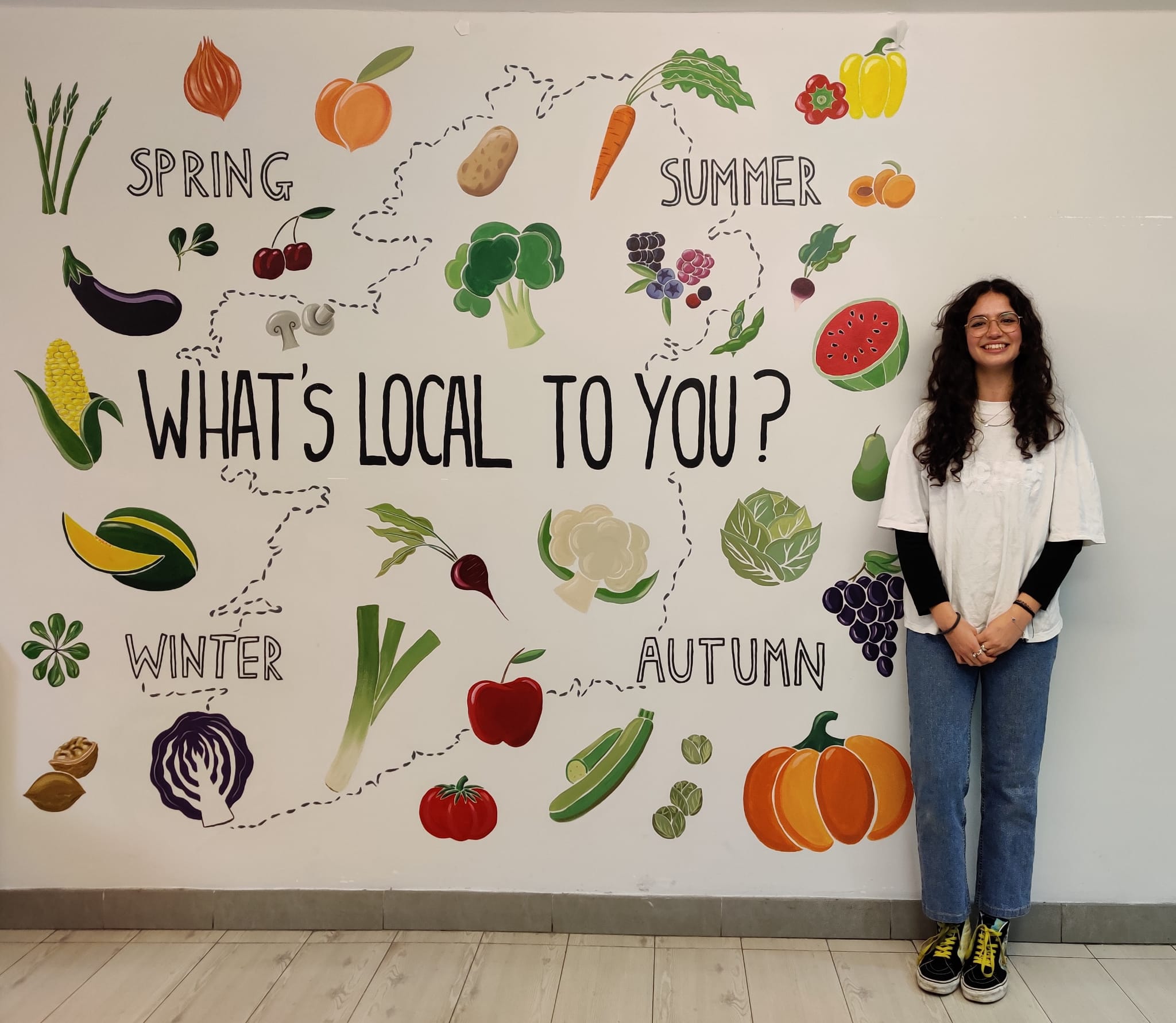 Irina Georgantzis Garcia with the food mural at the Buttery