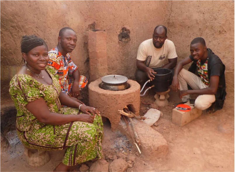 African villagers seated around a cooking stove