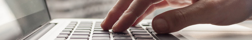 A person's hand typing at a keyboard