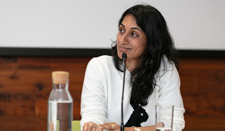 Nidhi Zak/Aria Eipe speaking into a microphone