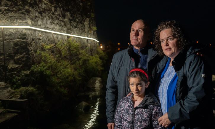 A family looking a the light installation on Spanish Arch
