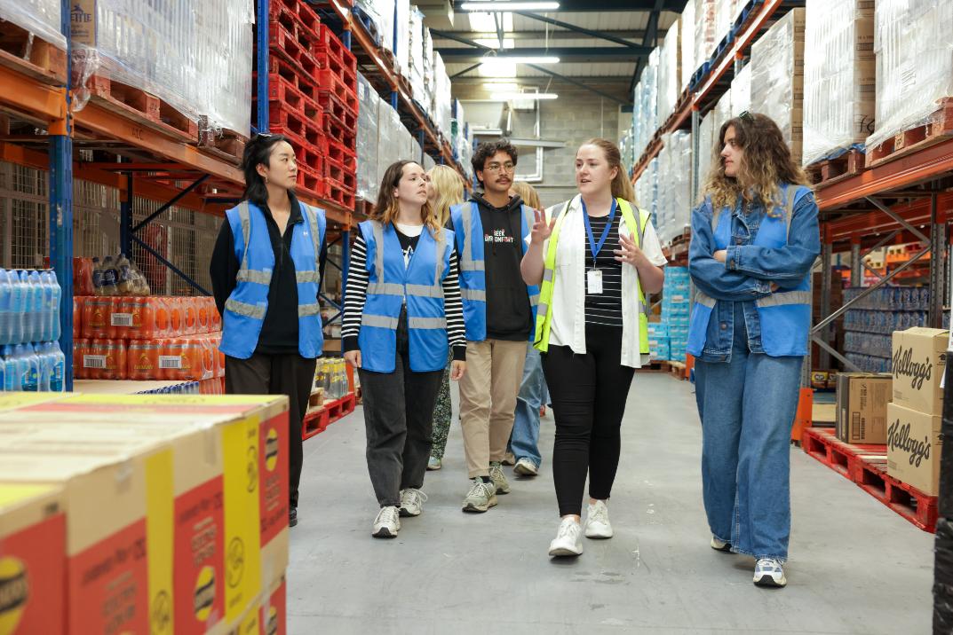 A group of people walks through a warehouse