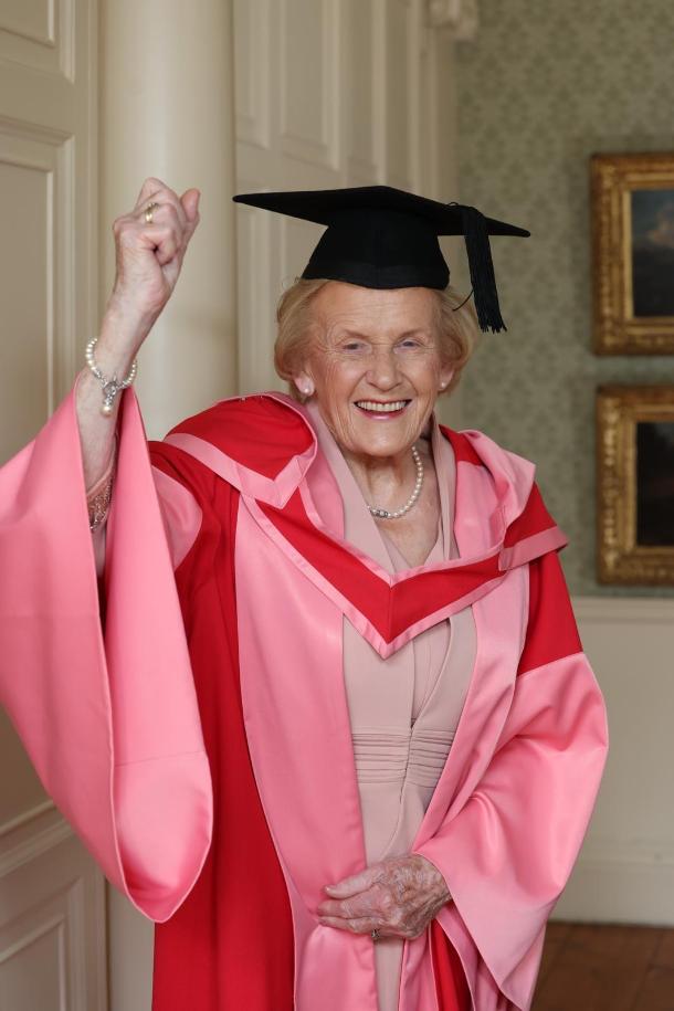 Smiling woman poses in academic robes