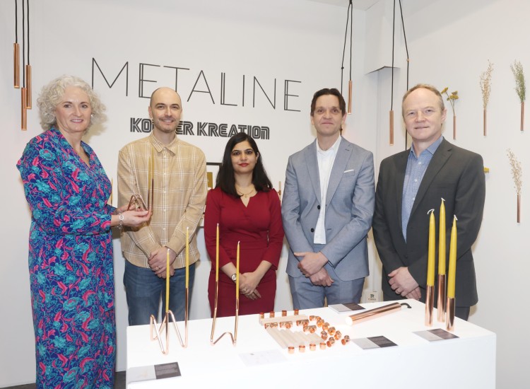 Five people pose with copper crafts