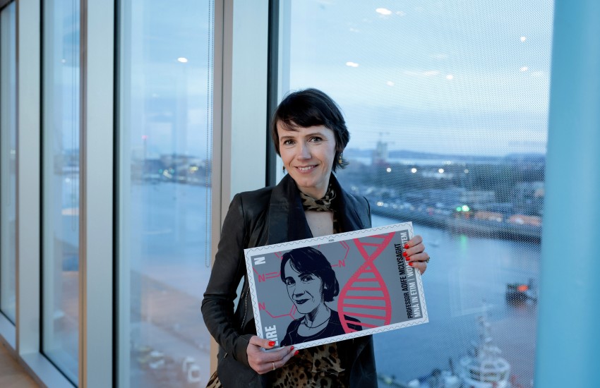 Woman holding oversixed image of stamp