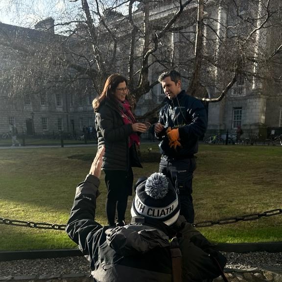 Two people by a tree being photographed