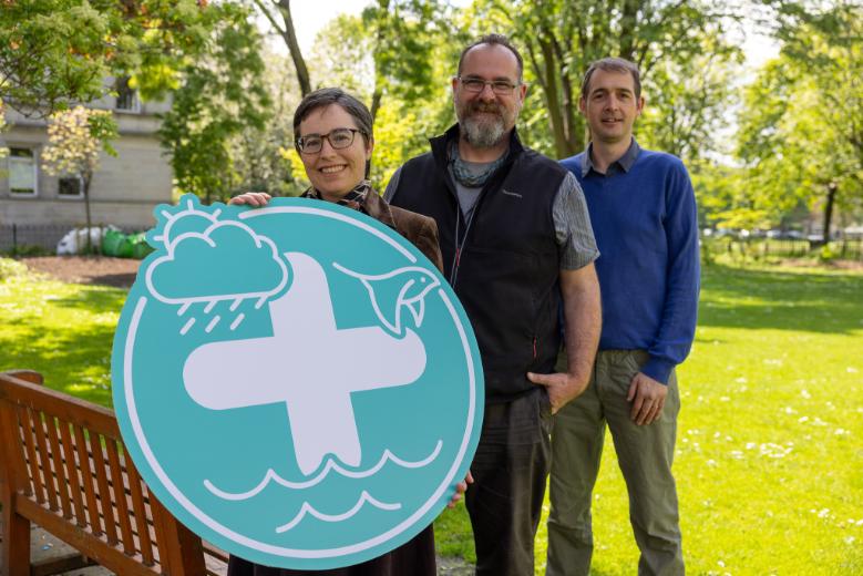 Profs. Yvonne Buckley, Mark Emmerson and Ed Hawkins stand with a circular + sign at the launch of the Climate + Biodiversity + Water Co-Centre.