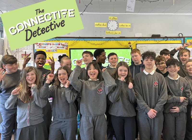 Primary school students in grey uniforms with their arms raised at The Connective Detective.