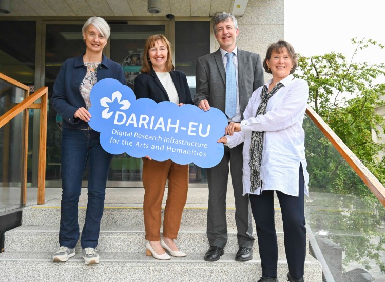 Four people holding a sign