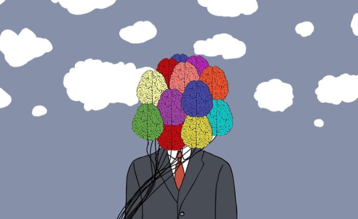 A cartoon showing a person in a black suit with various sections of their brain coloured in bright colours, including red, orange, green and blue. The person is standing against a grey background with white clouds all around them.