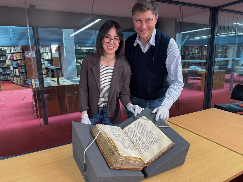 Photo of two people inspecting a medieval manuscript