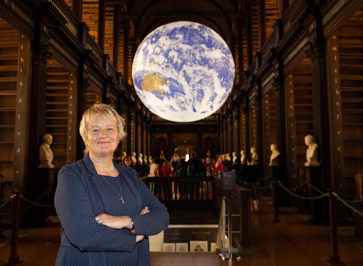 Woman poses beside Globe exhibit