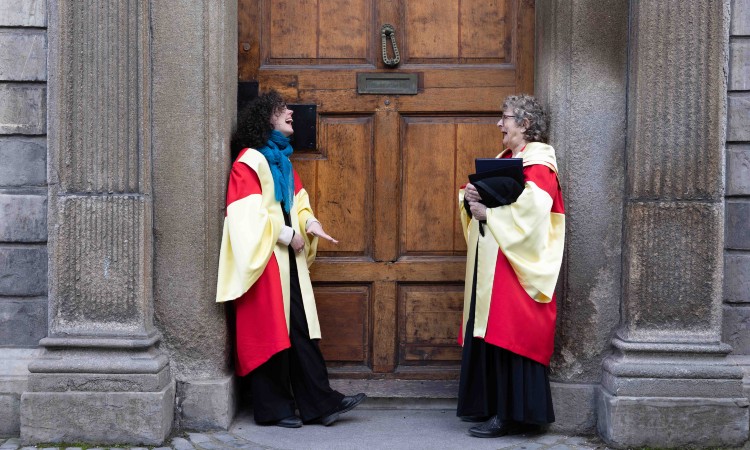 Two women in graduation robes at Trinity