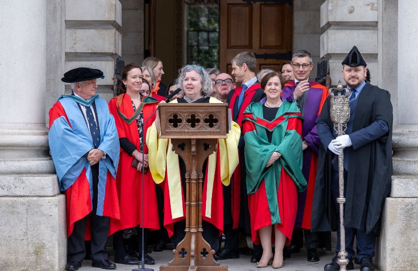 Group of robed academics behind a podium