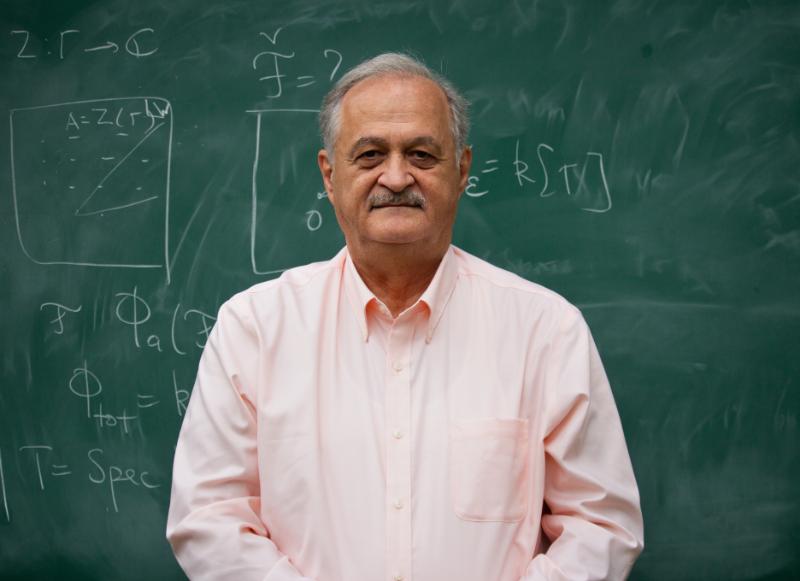 Prof. Samson Shatashvili in front of a teaching board with equations written on.
