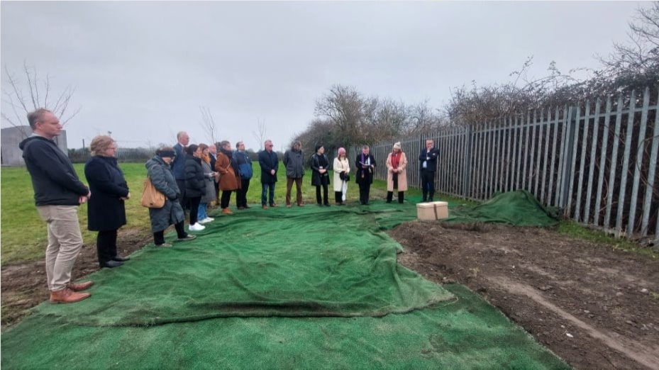 People standing around an open grave