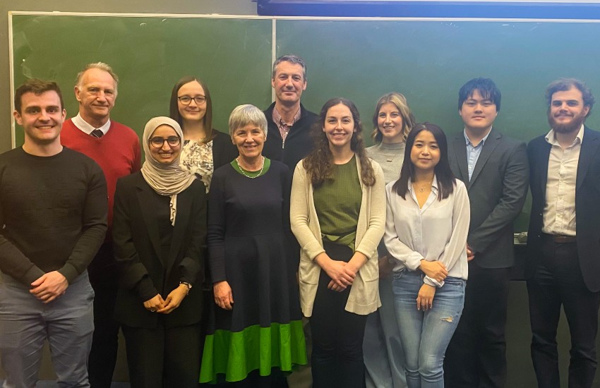 Group of people posing in a classroom