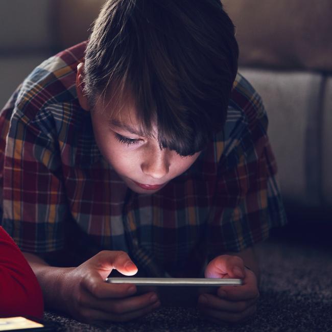 A teenage boy watching a video on his smartphone