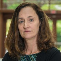 A headshot of a woman with brunette shoulder length hair