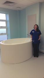 A Nursing and Midwifery graduate standing beside a birthing bath
