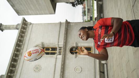 Linda throws rugby ball in air