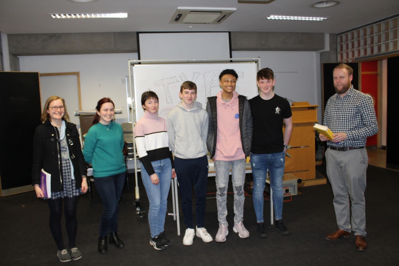 Students standing beside their poster who were winners in TYPE the best design category
