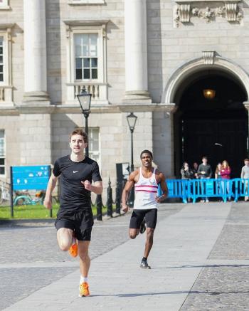 Two runners participating in the 2026 'Chariots of Fire' around Trinity's Front Square