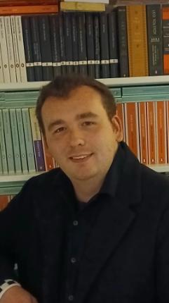 student with short brown hair, smiling at camera
