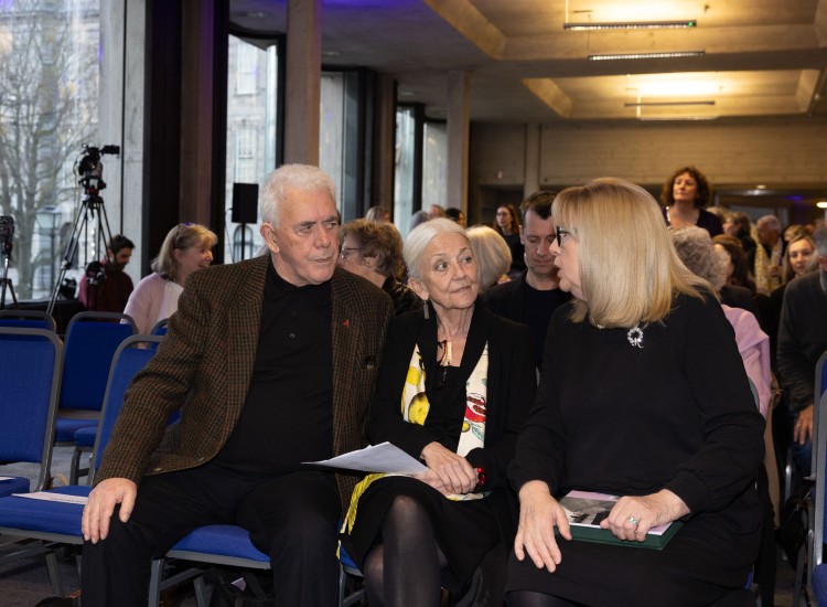 Two women and a man in conversation at an event