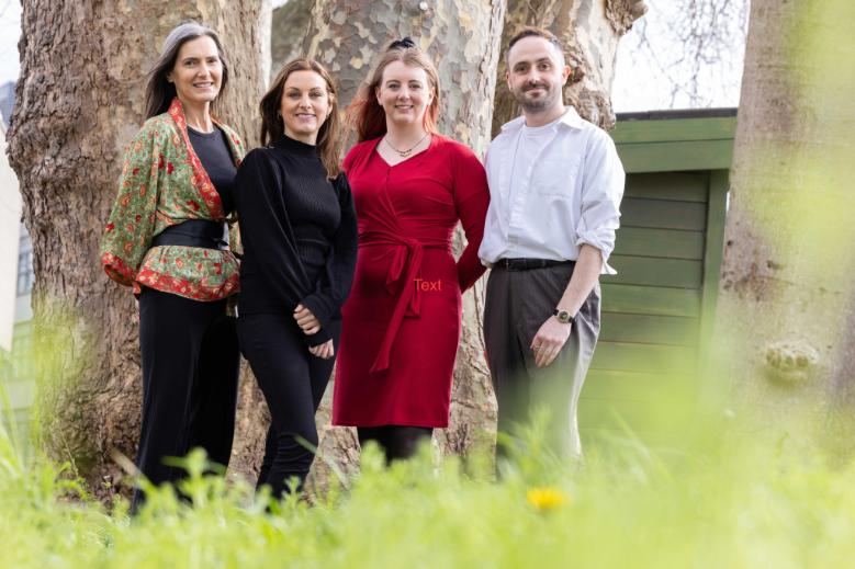 Four members of the CULTIVATE team pose by a tree