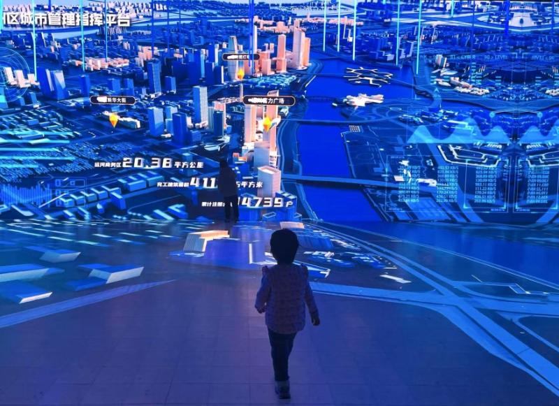 A person stands looking at an interactive dashboard of an existing City Brain system in China, at an interactive exhibition centre for the public.