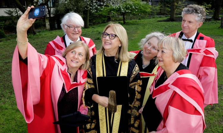 A group of gowned people taking a selfie
