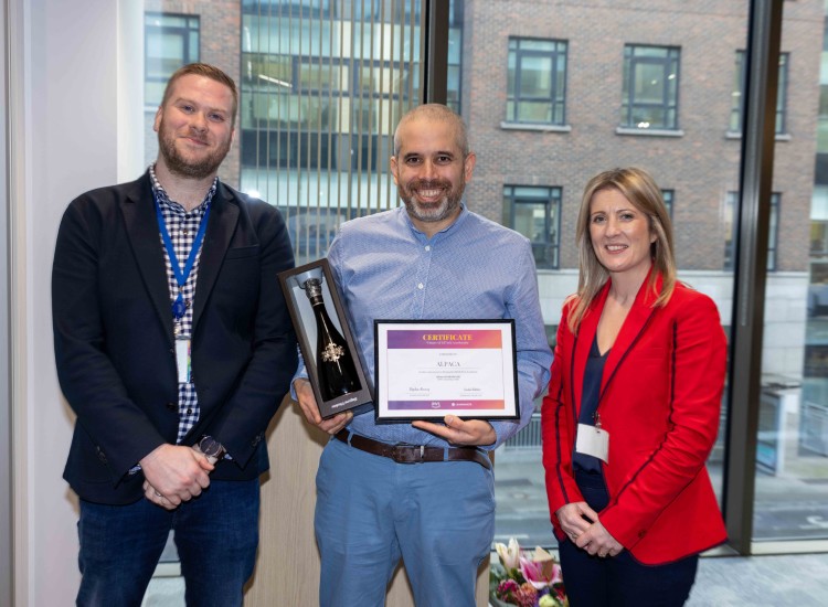 Two men and a woman with an award