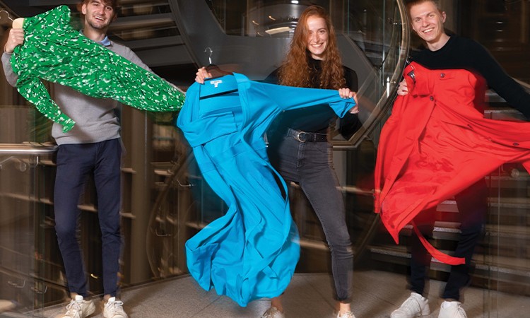 Three students with colourful fabric