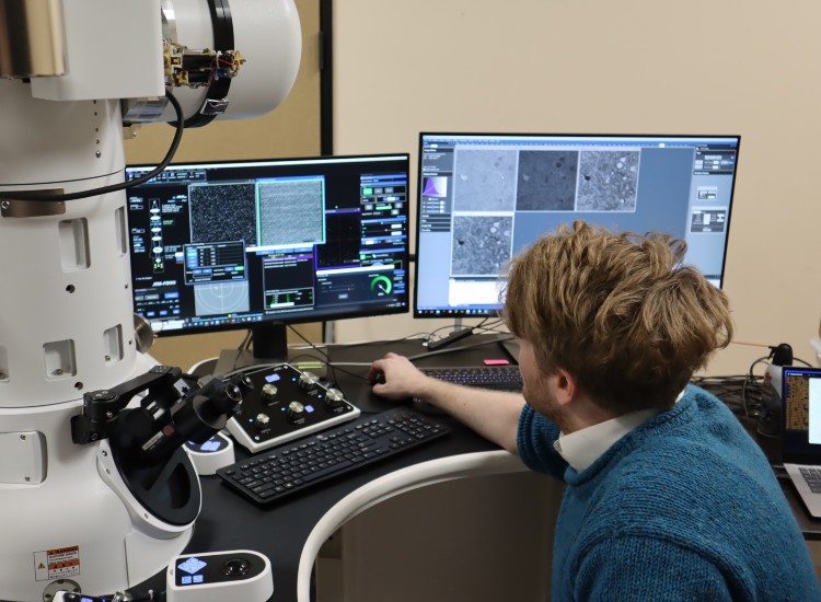 Man works on several computer screens