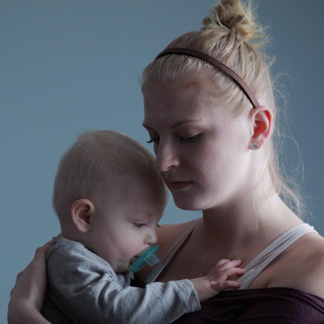 A mother with her young child. The mother looks depressed.