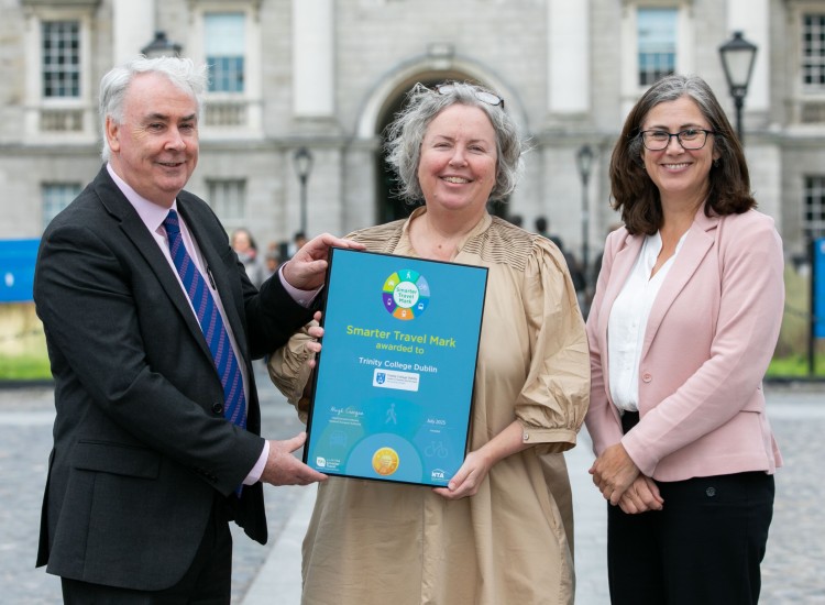A man and two women with an award