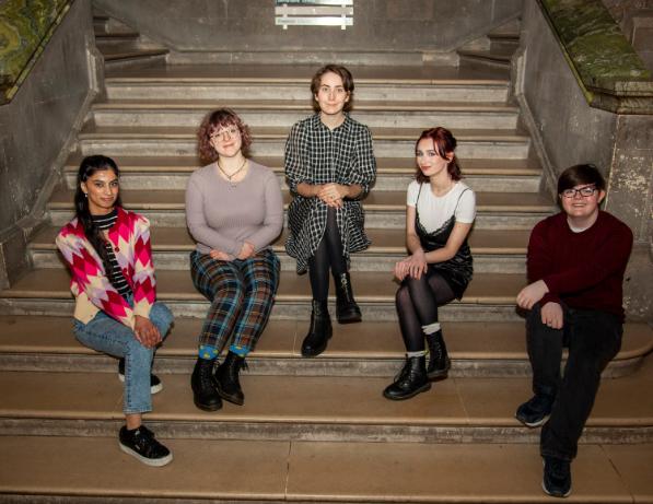 Five young women posing on a staircase