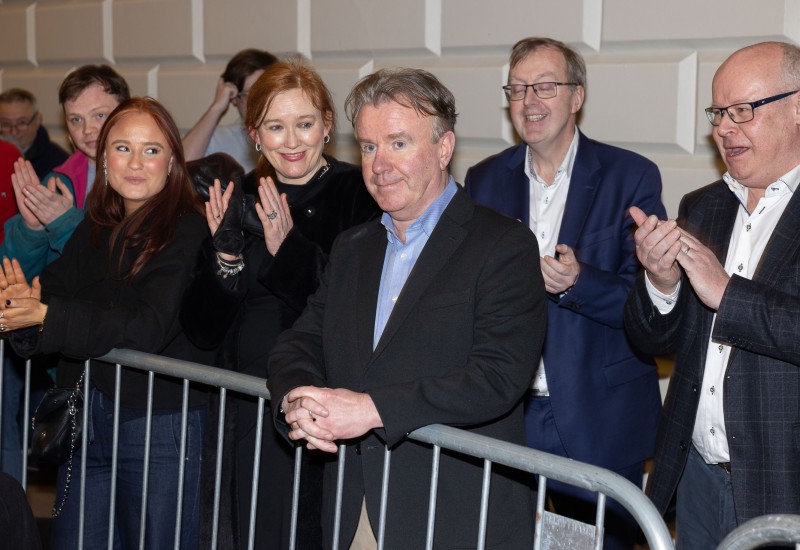 Man smiles as onlookers applaud